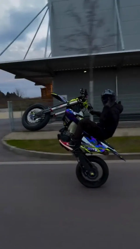 Supermoto with a blue and purple graphics kit in action