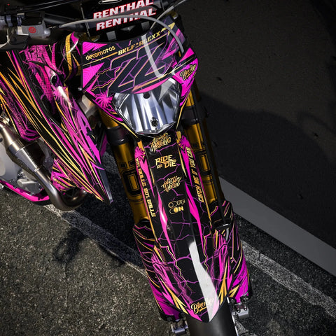 Supermoto with a pink and gold graphics kit, close-up