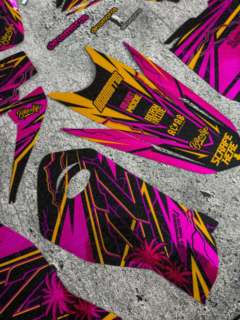 Pink and gold graphics kit laid out before fitting