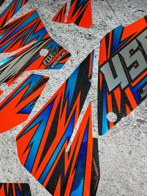 Red and blue graphics kit laid out before fitting