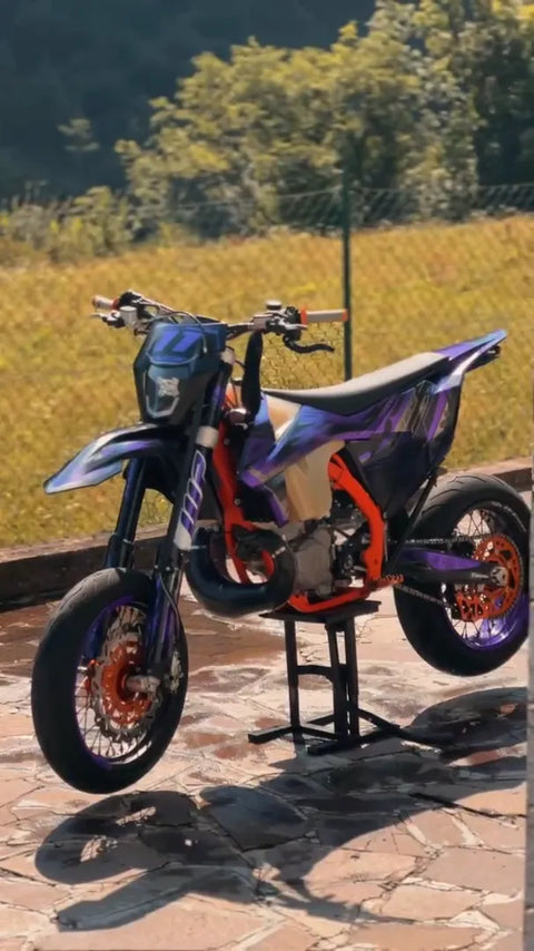 Supermotard con kit de adhesivos violeta y naranja recién colocado
