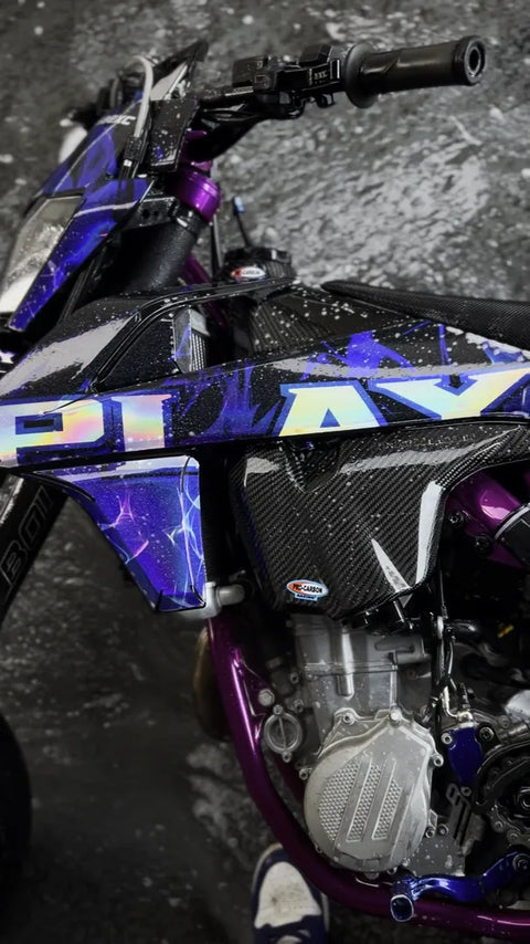 Supermotard con kit de adhesivos azul y violeta, primer plano