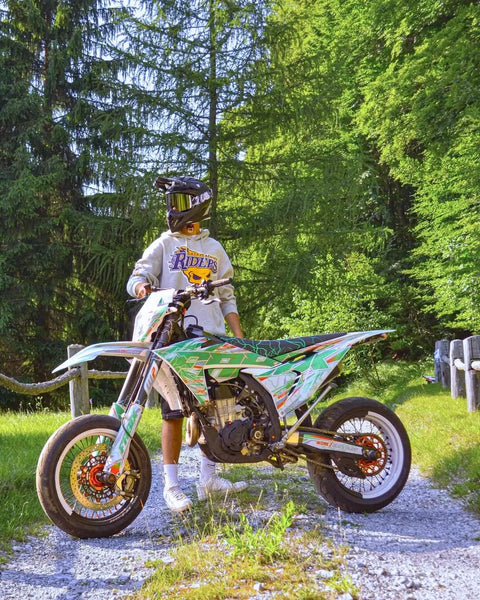 Motard et moto blanche au kit déco vert dans une clairière