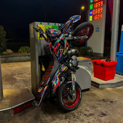 Supermotard photographié de nuit dans une station-service