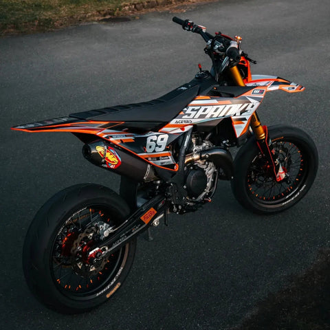 Supermotard noir et orange au numéro 69 photographié de profil