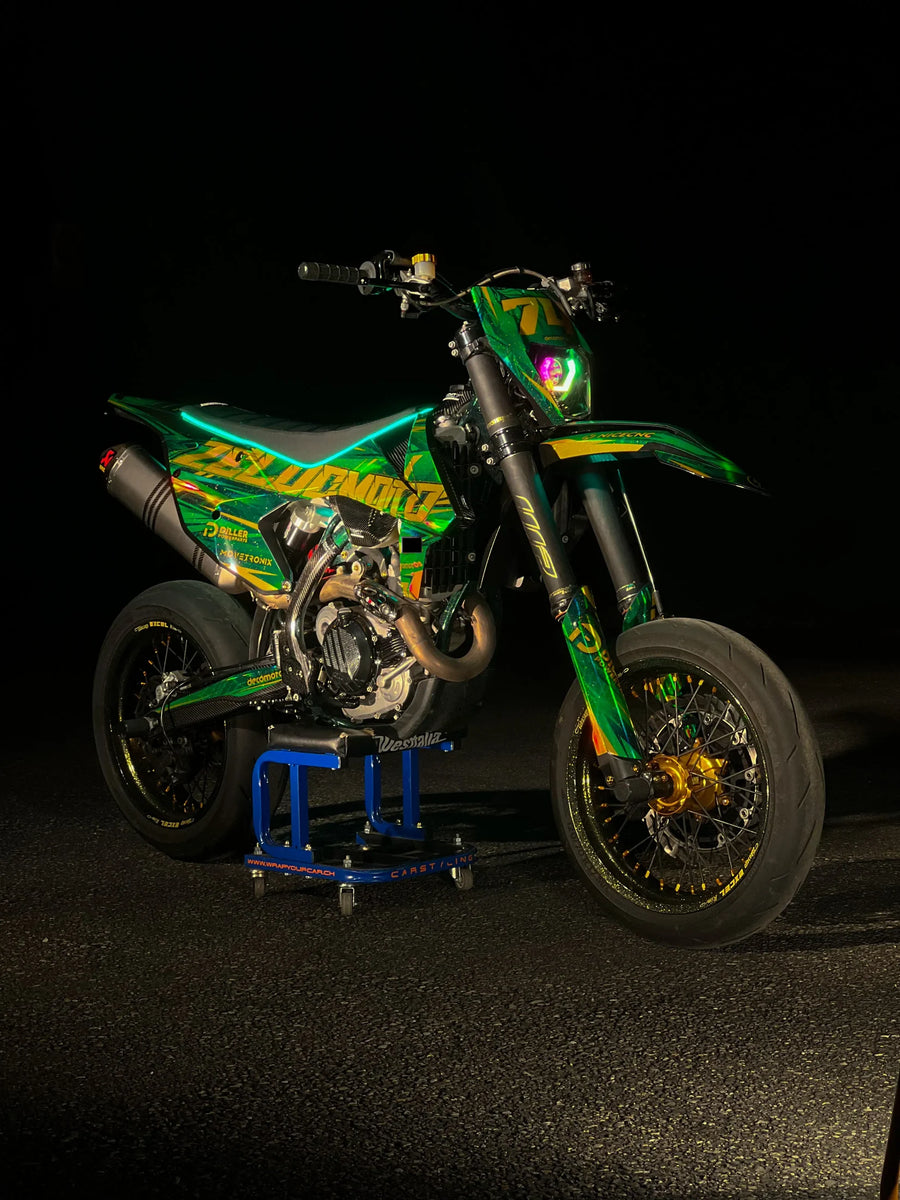 Supermotard con kit de adhesivos verde y amarillo sobre fondo negro
